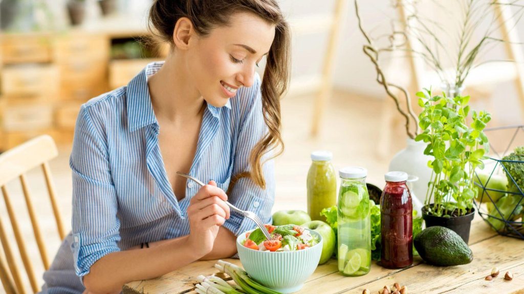 women eating fresh salad with salad dressing